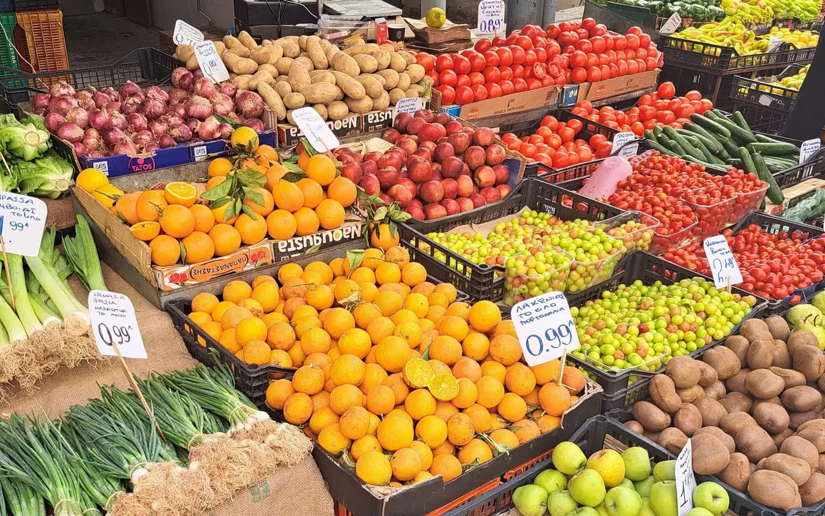 Pomarańcze, pomidory i warzywa liściaste na straganie