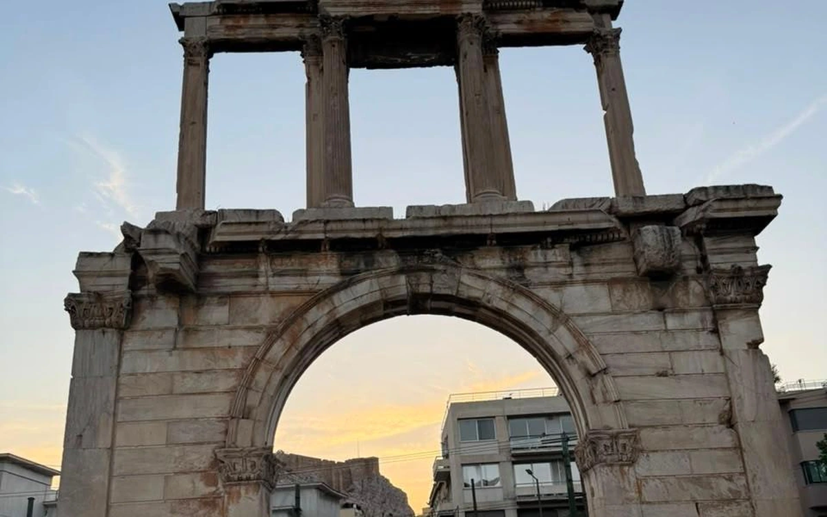 El Arco de Adriano en Atenas al atardecer, la roca de la Acrópolis vista a través del arco