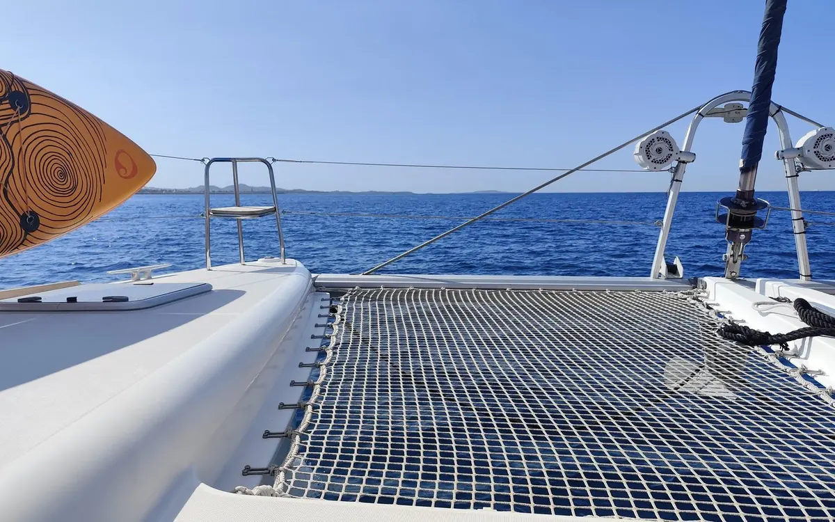 Siatki trampoliny na dziobie katamaranu, przed nimi otwarte morze