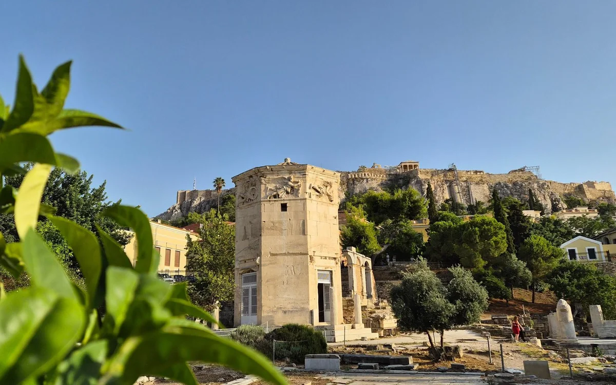 Torre octogonal de mármol en el Roman Agora, con la roca de la Acrópolis por encima