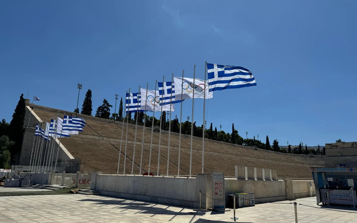 Banderas griega y olímpica frente a las gradas de mármol del Panathenaic Stadium